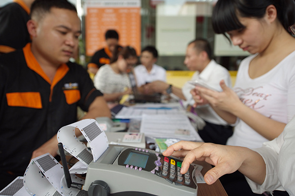 A bank in Qionghai, Hainan province, issues a bank card to a local resident. The China Banking Regulatory Commission has urged all commercial banks to issue bank cards using real names of the holders in a move to fight new frauds.(Photo/China Daily) A bank in Qionghai, Hainan province, issues a bank card to a local resident. The China Banking Regulatory Commission has urged all commercial banks to issue bank cards using real names of the holders in a move to fight new frauds.(Photo/China Daily)