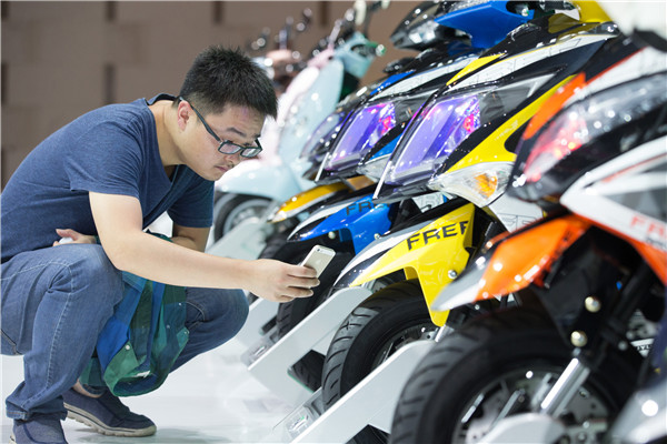 A visitor takes a photo of two-wheeled electric vehicles on display at a new energy vehicle exhibition in Nanjing, Jiangsu province.(SU YANG/CHINA DAILY) A visitor takes a photo of two-wheeled electric vehicles on display at a new energy vehicle exhibition in Nanjing, Jiangsu province.(SU YANG/CHINA DAILY)