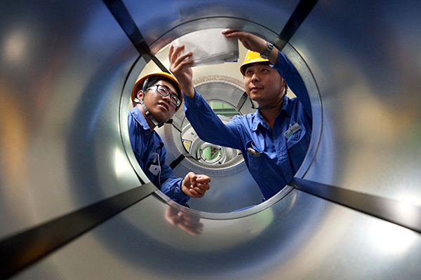 Two workers stick production identifications on steel products at a cold rolling mill of Tangsteel Group Ltd in Tangshan, Hebei province.(Photo/China Daily) Two workers stick production identifications on steel products at a cold rolling mill of Tangsteel Group Ltd in Tangshan, Hebei province.(Photo/China Daily)