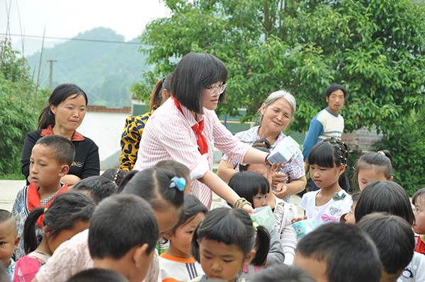 Liu Jiaying (wearing glasses) distributes gifts to students at Shaba primary school in Qianxi county, Guizhou province while visiting the school for the launch ceremony of the first Flying Box project in June, 2015. (Provided to CHINA DAILY) Liu Jiaying (wearing glasses) distributes gifts to students at Shaba primary school in Qianxi county, Guizhou province while visiting the school for the launch ceremony of the first Flying Box project in June, 2015. (Provided to CHINA DAILY)
