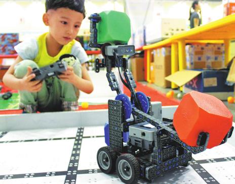 A child is attracted by a robot on display at a toy exhibition in Suzhou, Jiangsu province. (Wang Jiankang / for China Daily) A child is attracted by a robot on display at a toy exhibition in Suzhou, Jiangsu province. (Wang Jiankang / for China Daily)