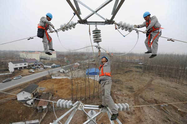 Workers fasten electric wires in a rural area in Chuzhou, Anhui province. (Song Weixing/For China Daily) Workers fasten electric wires in a rural area in Chuzhou, Anhui province. (Song Weixing/For China Daily)