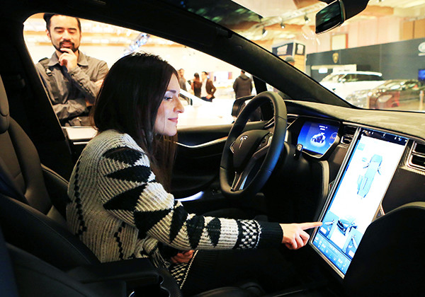 A woman experiences the touch screen of a Tesla car during an auto expo in Toronto, Canada. (Photo/Xinhua) A woman experiences the touch screen of a Tesla car during an auto expo in Toronto, Canada. (Photo/Xinhua)