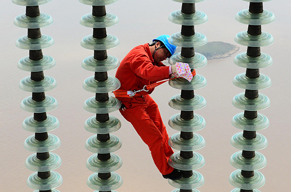 A worker from State Grid repairs power transmission facilities in Zhoushan, Zhejiang province. (Yao Feng/For China Daily) A worker from State Grid repairs power transmission facilities in Zhoushan, Zhejiang province. (Yao Feng/For China Daily)