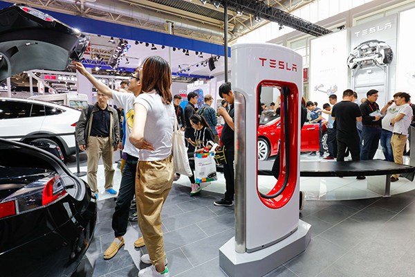 Tesla post stands beside a Tesla model during a recent auto fair in Beijing. (Photo/China Daily) Tesla post stands beside a Tesla model during a recent auto fair in Beijing. (Photo/China Daily)