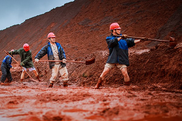 Workers of Magang (Group) Holding Co Ltd clear a cave-in of raw materials, caused by continuous rainstorms, in Ma'anshan, Anhui province. (Photo/China Daily) Workers of Magang (Group) Holding Co Ltd clear a cave-in of raw materials, caused by continuous rainstorms, in Ma'anshan, Anhui province. (Photo/China Daily)