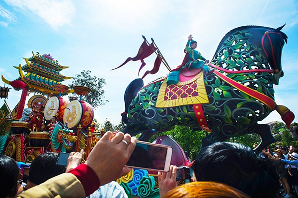 Visitors take pictures using mobile phones while a performer dressed as a Chinese traditional nomadic hero joins a parade of floats at Shanghai Disney Resort. (Photo provided to China Daily) Visitors take pictures using mobile phones while a performer dressed as a Chinese traditional nomadic hero joins a parade of floats at Shanghai Disney Resort. (Photo provided to China Daily)