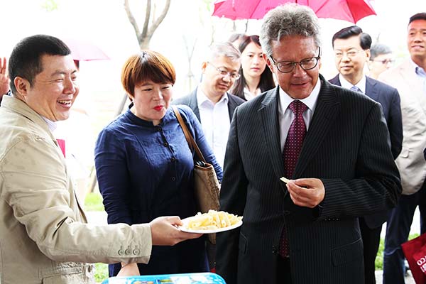 Ronald Keller, Dutch ambassador to China, tastes food at an exhibition in Beijing organized by China National Cereals, Oils and Food-stuffs Corp, a major State enterprise in China.(Provided to China Daily) Ronald Keller, Dutch ambassador to China, tastes food at an exhibition in Beijing organized by China National Cereals, Oils and Food-stuffs Corp, a major State enterprise in China.(Provided to China Daily)