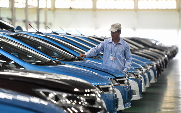 A worker checks electric vehicles made by BYD Co Ltd at the company's headquarters in Shenzhen, Guangdong province. (Photo/Xinhua) A worker checks electric vehicles made by BYD Co Ltd at the company's headquarters in Shenzhen, Guangdong province. (Photo/Xinhua)