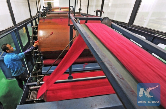 A staff member dusts a machine at a textile company in the Nanxun District of Huzhou City, east China's Zhejiang Province, Dec. 25, 2014. (Xinhua/Tan Jin) A staff member dusts a machine at a textile company in the Nanxun District of Huzhou City, east China's Zhejiang Province, Dec. 25, 2014. (Xinhua/Tan Jin)