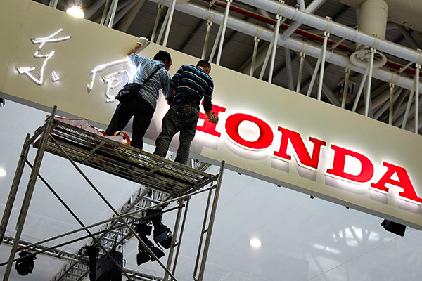 Workers decorate the Dongfeng Hongda exhibiting area at an auto show in Fuzhou, Fujian province. (Photo/China Daily) Workers decorate the Dongfeng Hongda exhibiting area at an auto show in Fuzhou, Fujian province. (Photo/China Daily)