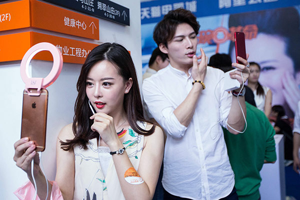 A woman and a man in a commercial live streaming event help sell essentials in Hangzhou, Zhejiang province. (Photo/China Daily) A woman and a man in a commercial live streaming event help sell essentials in Hangzhou, Zhejiang province. (Photo/China Daily)