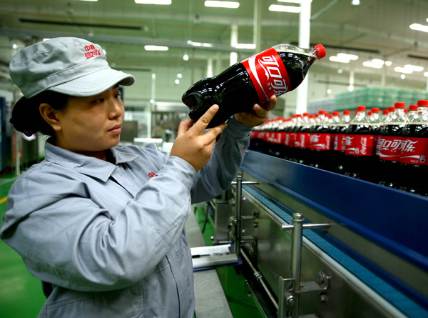 An employee of a COFCO Coca-Cola venture checks the packaging quality of drinks in a plant in Shijiazhuang, Hebei province. (Photo/Xinhua) An employee of a COFCO Coca-Cola venture checks the packaging quality of drinks in a plant in Shijiazhuang, Hebei province. (Photo/Xinhua)