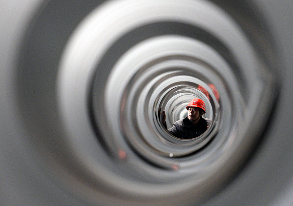 A worker of HeSteel Group Co Ltd's subsidiary checks steel plats for high-end automobile in Tangshan, North China's Hebei province, Feb 19, 2014. (Photo/Xinhua)