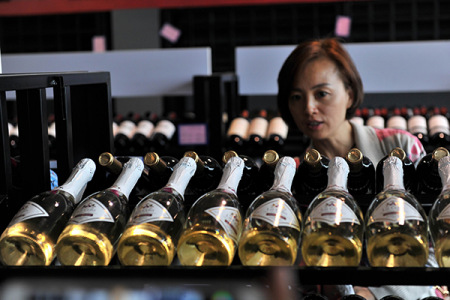 A woman examines imported wines at a duty-free shop in Qingdao, Shandong province. (Photo/China Daily) A woman examines imported wines at a duty-free shop in Qingdao, Shandong province. (Photo/China Daily)