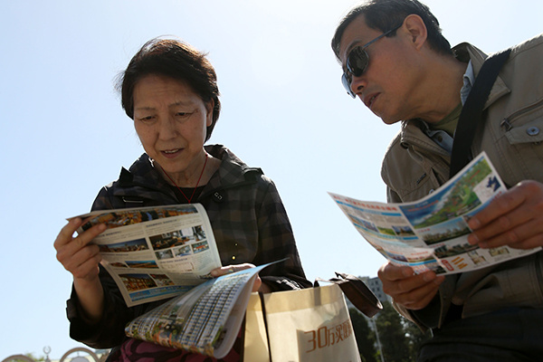 Potential homebuyers read advertisements at a property expo in Beijing in April. (Photo/China Daily) Potential homebuyers read advertisements at a property expo in Beijing in April. (Photo/China Daily)