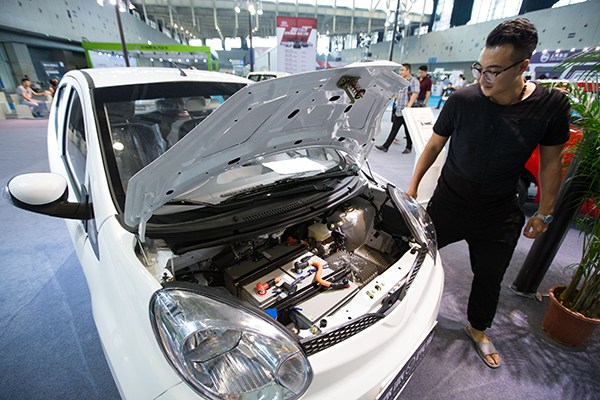 A visitor examines a new energy car at an auto exhibition in Nanjing, Jiangsu province, in early September. (Photo/China Daily) A visitor examines a new energy car at an auto exhibition in Nanjing, Jiangsu province, in early September. (Photo/China Daily)