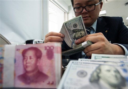 An employee at a bank counter in Nantong, Jiangsu province, counts renminbi and dollars. (Photo/China Daily) An employee at a bank counter in Nantong, Jiangsu province, counts renminbi and dollars. (Photo/China Daily)