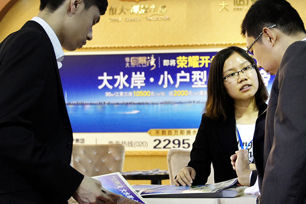 A China Evergrande salesperson introduces the property developer's apartment project to customers at a real estate expo in Guangzhou, Guangdong province. (Photo provided to China Daily) A China Evergrande salesperson introduces the property developer's apartment project to customers at a real estate expo in Guangzhou, Guangdong province. (Photo provided to China Daily)