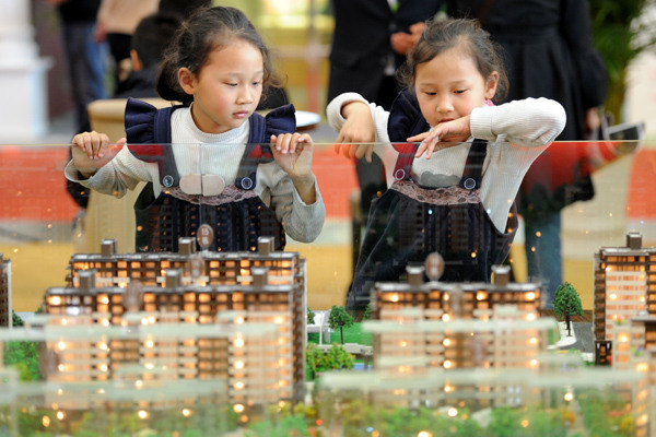 Twin sisters check out a model of a building at a real estate expo in Nanjing. The second-child policy is expected to fuel people's demand for larger homes. (Photo by You You/For China Daily) Twin sisters check out a model of a building at a real estate expo in Nanjing. The second-child policy is expected to fuel people's demand for larger homes. (Photo by You You/For China Daily)