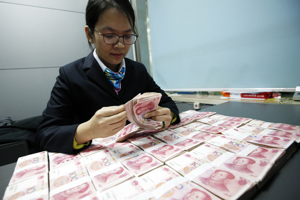 A worker at the Industrial and Commercial Bank of China counts banknotes at a branch in Huaibei, Anhui province, on Dec 1, 2015. (Photo by Xie Zhengyi/For China Daily) A worker at the Industrial and Commercial Bank of China counts banknotes at a branch in Huaibei, Anhui province, on Dec 1, 2015. (Photo by Xie Zhengyi/For China Daily)