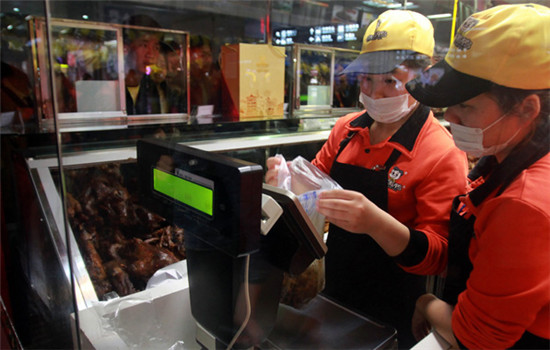 Two employees weigh products at a Zhouheiya store at a railway station in Wuchang, Hubei province. (CHINA NEWS SERVICE) Two employees weigh products at a Zhouheiya store at a railway station in Wuchang, Hubei province. (CHINA NEWS SERVICE)
