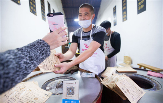 A tourist buys food via Alipay, the mobile payment service of Ant Financial Services Group, in Wuzhen, Zhejiang province.( XU KANGPING / FOR CHINA DAILY) A tourist buys food via Alipay, the mobile payment service of Ant Financial Services Group, in Wuzhen, Zhejiang province.( XU KANGPING / FOR CHINA DAILY)
