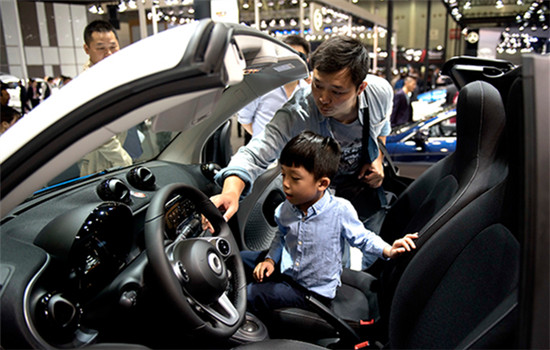 A visitor and his child try out a new car at an auto show in Wuhan, Hubei province, on Oct 12,2016. (Photo/Xinhua) A visitor and his child try out a new car at an auto show in Wuhan, Hubei province, on Oct 12,2016. (Photo/Xinhua)