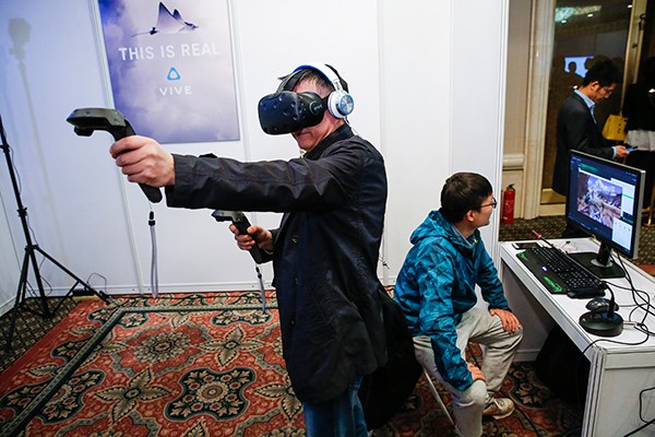 A visitor tests HTC's VR facilities at a 5G technology and test seminar held in Beijing in April. (Photo/Xinhua) A visitor tests HTC's VR facilities at a 5G technology and test seminar held in Beijing in April. (Photo/Xinhua)