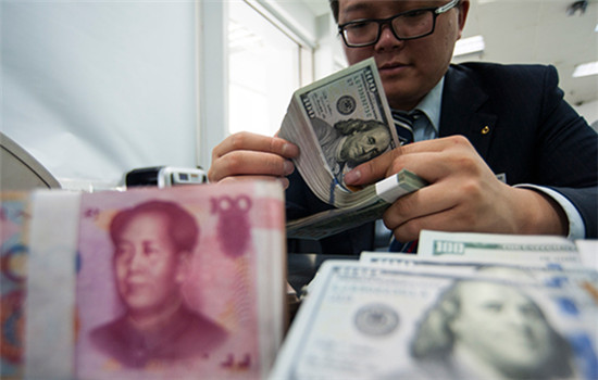 An employee at a bank counter in Nantong, Jiangsu province, counts renminbi and dollars. (Photo/China Daily) An employee at a bank counter in Nantong, Jiangsu province, counts renminbi and dollars. (Photo/China Daily)