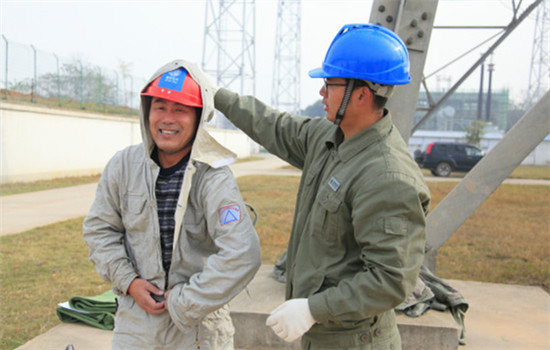 Yan Yu, son of Yan Xudong, assists him in taking off the screen clothes after he completed his work on UHV electricity cables at a UHV AC Test Base of SGCC in Wuhan, capital of Central China's Hubei province, on November 30, 2016. (Photo by Zhu Lingqing/chinadaily.com.cn) Yan Yu, son of Yan Xudong, assists him in taking off the screen clothes after he completed his work on UHV electricity cables at a UHV AC Test Base of SGCC in Wuhan, capital of Central China's Hubei province, on November 30, 2016. (Photo by Zhu Lingqing/chinadaily.com.cn)