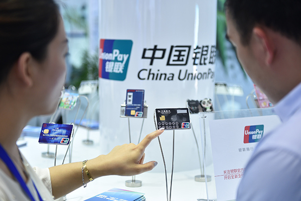 A UnionPay employee introduces new bank card services to a visitor at a show in Beijing. (Photo/Xinhua) A UnionPay employee introduces new bank card services to a visitor at a show in Beijing. (Photo/Xinhua)