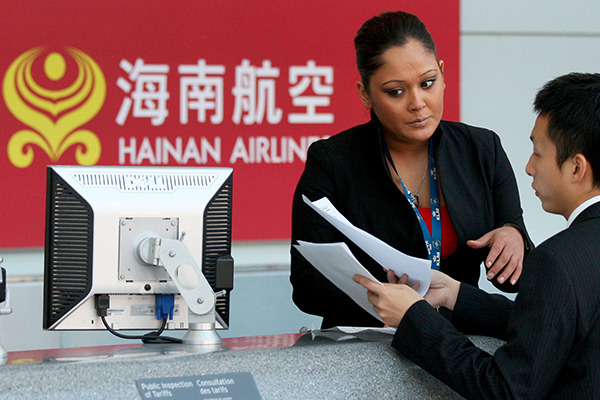 Two ground staff of Hainan Airlines prepare lists of passengers at the Pearson International Airport in Toronto, Canada. (Photo/Xinhua) Two ground staff of Hainan Airlines prepare lists of passengers at the Pearson International Airport in Toronto, Canada. (Photo/Xinhua)