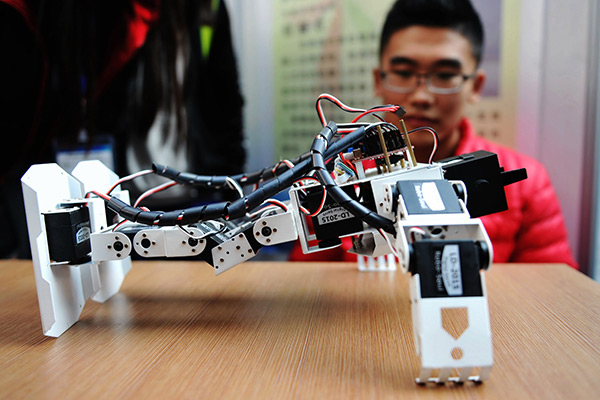 A voice-controlled robot designed by college students does push-ups at a show in Shandong province. (Photo/China Daily) A voice-controlled robot designed by college students does push-ups at a show in Shandong province. (Photo/China Daily)