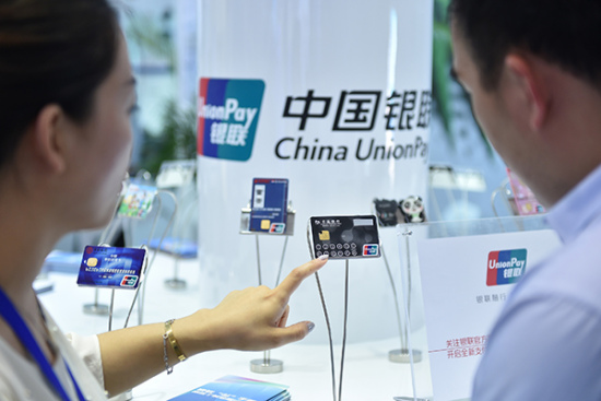 A UnionPay employee introduces new bank card services to a visitor at a show in Beijing. (Photo/Xinhua) A UnionPay employee introduces new bank card services to a visitor at a show in Beijing. (Photo/Xinhua)
