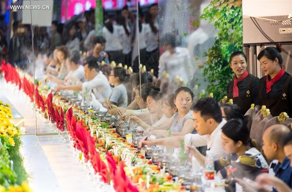 Diners eat around an extra large hotpot at the 8th China (Chongqing) Hotpot and Food Culture Festival in Southwest China's Chongqing, Oct 20, 2016. (Photo/Xinhua) Diners eat around an extra large hotpot at the 8th China (Chongqing) Hotpot and Food Culture Festival in Southwest China's Chongqing, Oct 20, 2016. (Photo/Xinhua)