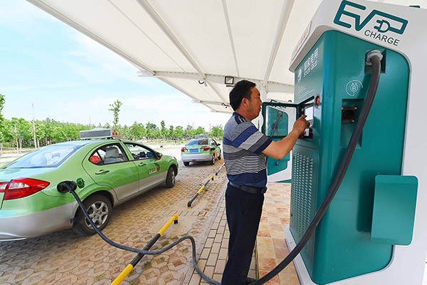 A taxi driver charges his electric car at a station in Weifang, Shandong province. (Photo/China Daily) A taxi driver charges his electric car at a station in Weifang, Shandong province. (Photo/China Daily)