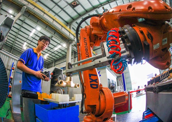 A worker assembles a robotic arm at a factory in Foshan, Guangdong province. (Provided to China Daily) A worker assembles a robotic arm at a factory in Foshan, Guangdong province. (Provided to China Daily)