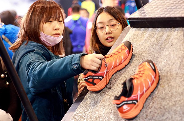 Visitors check shoes at the ISPO outdoor sports expo in Beijing in February. (Photo by Zou Hong/China Daily) Visitors check shoes at the ISPO outdoor sports expo in Beijing in February. (Photo by Zou Hong/China Daily)