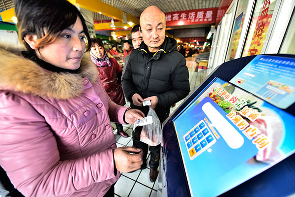 A customer traces the origin of her products at a market in Hefei, capital of Anhui province, in January. (Photo/China Daily) A customer traces the origin of her products at a market in Hefei, capital of Anhui province, in January. (Photo/China Daily)