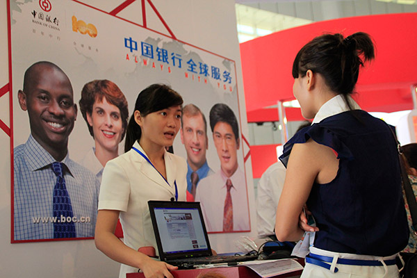 A clerk (left) in an outlet of Bank of China in Haikou, Hainan province, answers a customer's queries. (Photo/China Daily) A clerk (left) in an outlet of Bank of China in Haikou, Hainan province, answers a customer's queries. (Photo/China Daily)