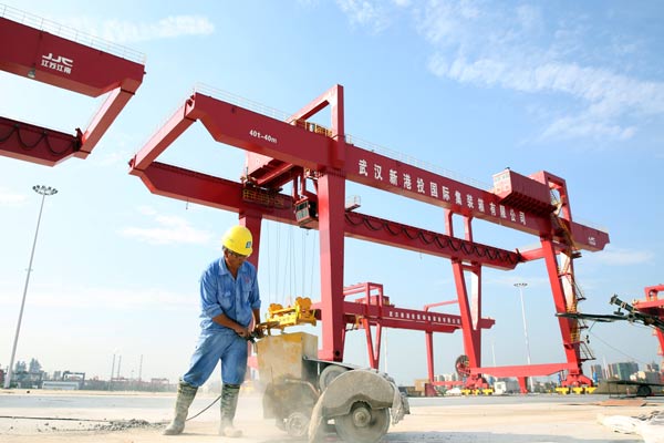 A worker operates a machine in Yangluo Port in Wuhan, Hubei province. (Photo by Xiao Jingsong/For China Daily)