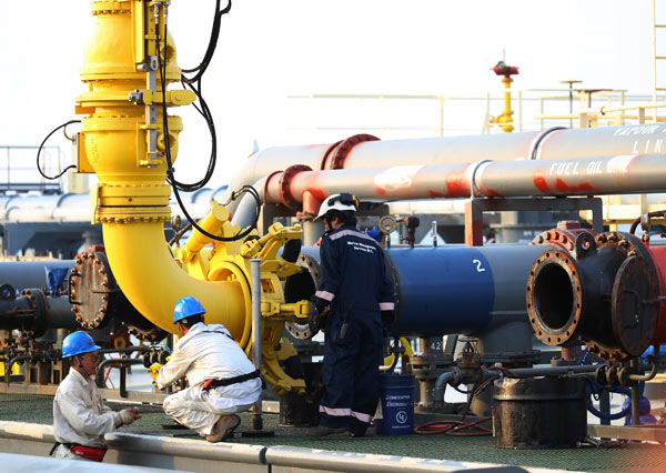 Workers connect a conduit to the 140,000-ton crude tanker Suezmax, to unload oil at Made Island oil port in Myanmar on Monday. Crude oil will then be transported to China via the China-Myanmar crude oil pipeline. (Photo/Xinhua) Workers connect a conduit to the 140,000-ton crude tanker Suezmax, to unload oil at Made Island oil port in Myanmar on Monday. Crude oil will then be transported to China via the China-Myanmar crude oil pipeline. (Photo/Xinhua)
