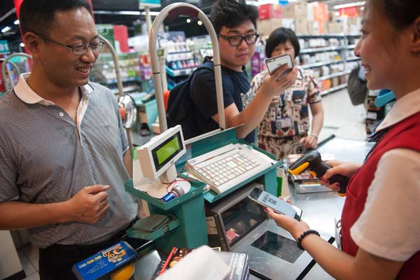 A cashier scans a buyer's WeChat Pay code on his mobile phone at a supermarket in Shenzhen, Guangdong province. (Photo provided to China Daily) A cashier scans a buyer's WeChat Pay code on his mobile phone at a supermarket in Shenzhen, Guangdong province. (Photo provided to China Daily)