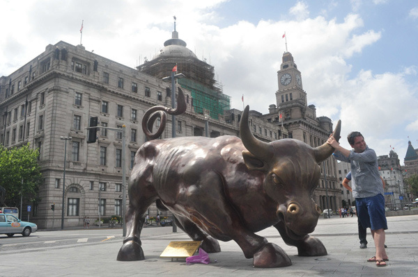 A tourist poses in front of the bull statue at the Bund in Shanghai. The city has progressed in rankings of global financial centers. (Photo by Yan Daming/For China Daily) A tourist poses in front of the bull statue at the Bund in Shanghai. The city has progressed in rankings of global financial centers. (Photo by Yan Daming/For China Daily)