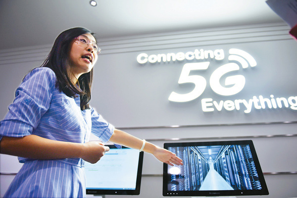 An employee from China Mobile Ltd explains 5G technology at an exhibition hall in Beijing. (Photo/Xinhua) An employee from China Mobile Ltd explains 5G technology at an exhibition hall in Beijing. (Photo/Xinhua)