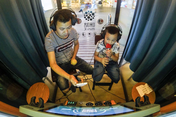 Customers sing at the mini karaoke booths in the basement of the Tianfu Square in Chengdu, capital of Sichuan province. There are four such mini booths here. It will cost 80 yuan ($11.6) for an hour of singing. (Photo by Hao Fei/For China Daily) Customers sing at the mini karaoke booths in the basement of the Tianfu Square in Chengdu, capital of Sichuan province. There are four such mini booths here. It will cost 80 yuan ($11.6) for an hour of singing. (Photo by Hao Fei/For China Daily)