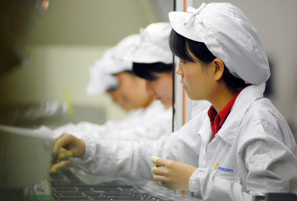Workers at a Foxconn Technology Group plant in Shenzhen, Guangdong province. The tech giant will enhance its production capacity at its plants in Hengyang, Hunan province. WANG LEI / FOR CHINA DAILY