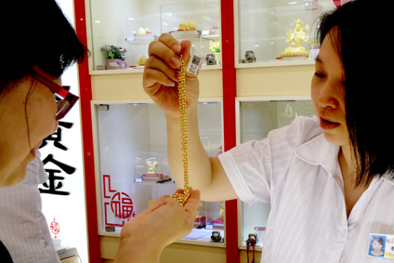 A shop assistant helps a customer to choose gold jewelry in Beijing. (Photo: CAO BOYUAN / FOR CHINA DAILY) A shop assistant helps a customer to choose gold jewelry in Beijing. (Photo: CAO BOYUAN / FOR CHINA DAILY)