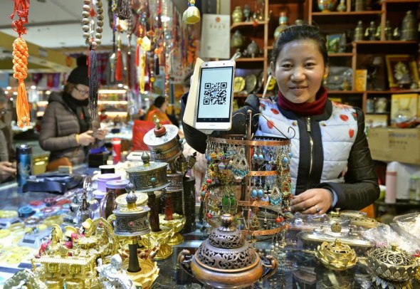 A woman shows the QR code for mobile payment at her shop in Lhasa, Tibet autonomous region, on Jan 4, 2017. (Photo/Xinhua) A woman shows the QR code for mobile payment at her shop in Lhasa, Tibet autonomous region, on Jan 4, 2017. (Photo/Xinhua)